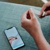 Person applying the NightOwl home sleep test device to their finger