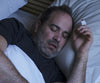 Person sleeping with the NightOwl home sleep test device on their finger